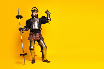 Man in medieval knight armor posing with a barbell on a vibrant yellow background