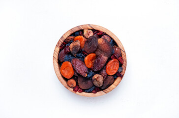 Organic sun dried fruits mix in bowl on white background. Healthy snacks instead of sugar and candy, source of vitamins and microelements. Top view