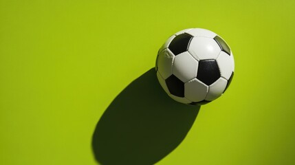 Simple flat lay of a soccer ball on a bright green background, minimal shadows, isolated, no people
