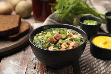 Delicious okroshka soup with kvass and ingredients on wooden table, closeup