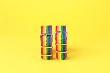 Two wristbands in LGBT colors on yellow background