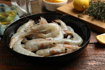 Fresh raw shrimps and spices on wooden table, closeup