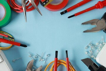 Frame of different electrical tools on light blue background, flat lay. Space for text