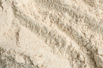 Brown rice flour as background, closeup view