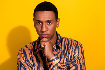 Young man in a trendy patterned shirt against a vibrant yellow background