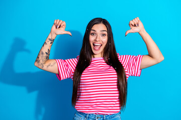 Smiling Woman in a Striped T-Shirt Making Enthusiastic Gestures Against a Bright Blue Background