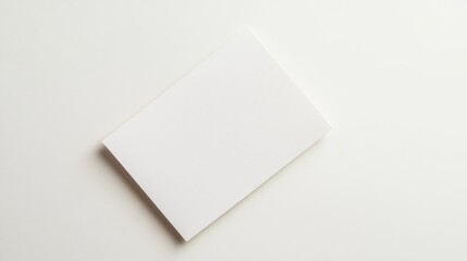 Blank white paper notepad on white surface, top view, empty space for design