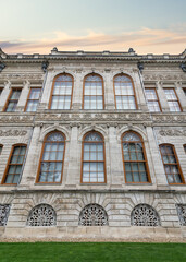 The side wall of Dolmabahce Palace features a small wooden door and arched windows. The palace is situated in the Besiktas district on the European coast of the Bosporus, Istanbul, Turkey