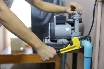 Plumber using a wrench to repair a water pipe. Concept of water pump maintenance fix water plumbing leaks drop or house bathroom service or cleaning clogged pipes is dirty or rusty.