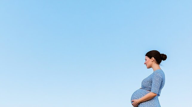Expecting Mother Embracing the Joy of Pregnancy Against a Clear Sky