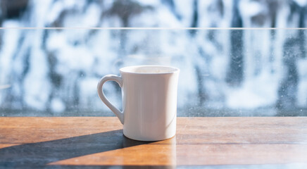 White coffee mug with snow background in winter