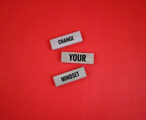 Motivational Words on Wooden Blocks with Spelling 'Change Your Mindset' on Red Background