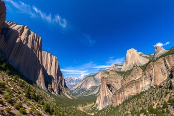 A breathtaking view of rugged mountain cliffs and lush green valleys under a vibrant blue sky