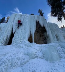 Climber scaling a frozen waterfall