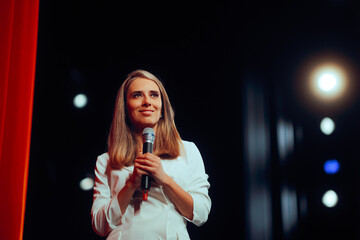 Woman in White Blazer Dress Holding Microphone on Stage. Businesswoman teaching and mentoring about leadership and success 
