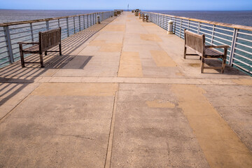 Hermosa Beach Pier, empty without people on a sunny week day facing the ocean horizon