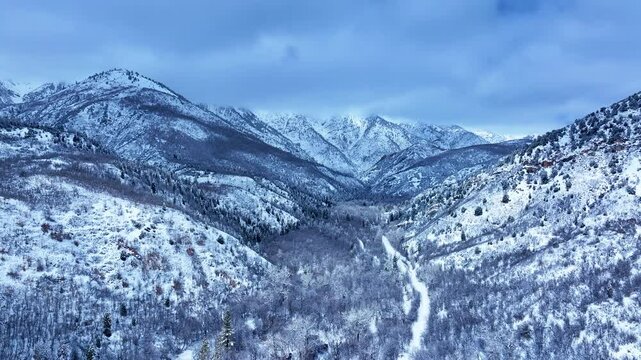 Aerial Mount Nebo Utah winter snow mountain valley road. Beautiful late winter Wasatch Mountains. Valley and alpine landscape. Cold weather cloud environment. Rocky ledges, cliffs, canyon valleys. 