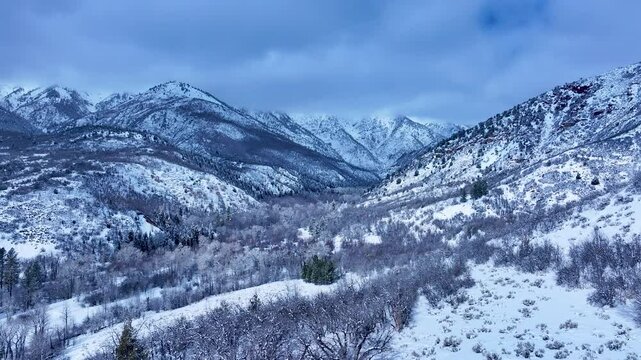Aerial Mount Nebo Utah winter snow mountain valley 3. Beautiful late winter Wasatch Mountains. Valley and alpine landscape. Cold weather cloud environment. Rocky ledges, cliffs, canyon and valleys. 