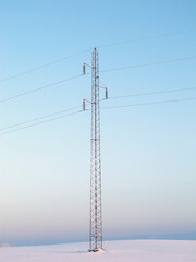 Electricity, power lines and snow landscape for industrial energy, engineering and antenna. Blue sky, winter background and electrical pylon or pole outdoor for infrastructure, wires or cable network
