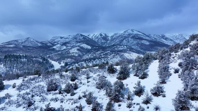 Aerial Mount Nebo Utah winter snow mountain valley 1. Beautiful late winter Wasatch Mountains. Valley and alpine landscape. Cold weather cloud environment. Rocky ledges, cliffs, canyon and valleys. 