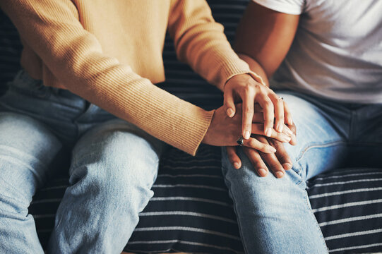 Home, couch and couple with holding hands for support, compassion or bonding together in relationship. House, lounge or partners in healthy marriage for connection, empathy or love on sofa by closeup