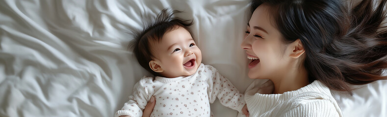 침대위에서 엄마와 애기가 서로 보면서 웃고있다.
Mother and baby are looking at each other and smiling on the bed.