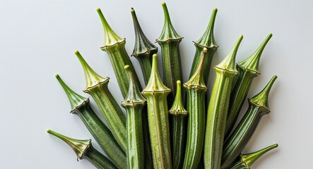 Obraz premium bunch of fresh okra pods with pointed tips on plain white background