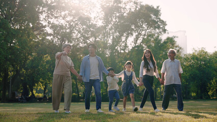 Happy Asian family walking in the park, Outdoor with big family and summer season concept