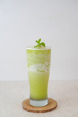 Delicious And Refreshing Green Smoothie Served In A Tall Glass With Mint Garnish On A Wooden Coaster, Perfect For A Healthy, And Invigorating Drink.