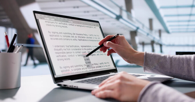 Young woman proofreads script on laptop, corrects errors