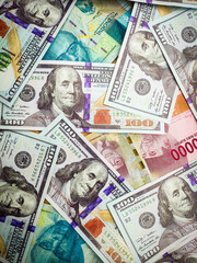 background of piles of US dollar banknotes overlapping Indonesian rupiah banknotes. illustration of inflation of the US dollar currency against the Indonesian rupiah currency