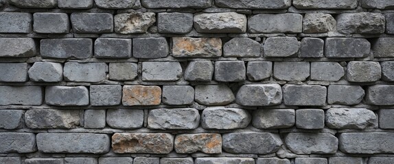 Obraz premium Gray brick wall texture with uneven surface and varied stone shapes arranged in horizontal pattern