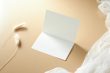 Blank Greeting Card and Decorative Elements on a Smooth Beige Surface