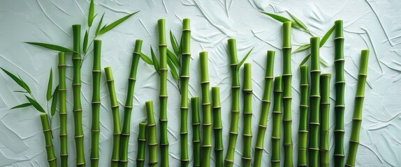 Green bamboo stalks with leaves arranged vertically on textured light background