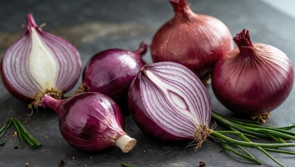 Red onions arranged on a dark surface with chives scattered around showcasing their vivid color and texture.