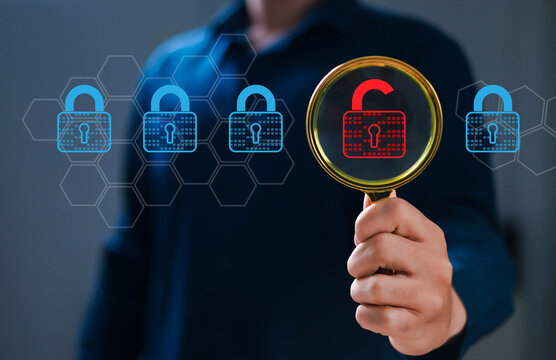 Hand holding magnifying glass, security engineer identifying data security vulnerabilities in internet network, unlocked padlock icon and many more locked padlock icons.