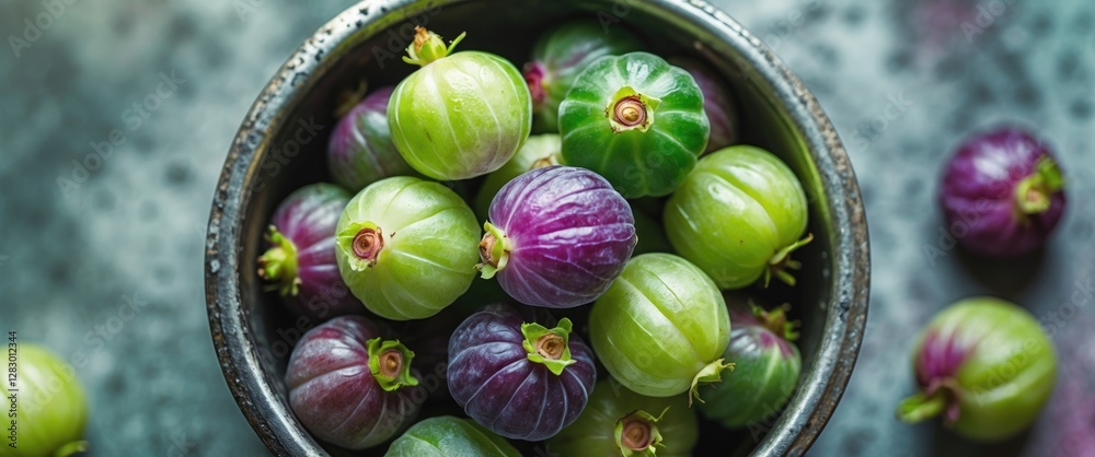 Aufkleber fresh green and purple gooseberries in a rustic bowl on a textured surface with scattered berries ar