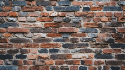Obraz premium Textured brick wall with a mixture of reddish and gray stones arranged in an irregular pattern and weathered appearance