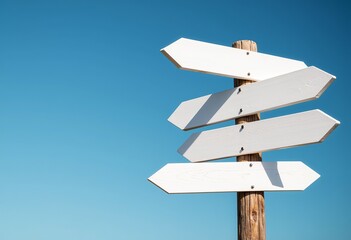 Choose Your Direction: A white wooden signpost stands tall with arrows pointing every which way, set against a clear blue sky, symbolizing opportunities and decision-making.

