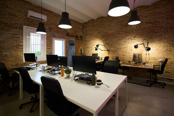 Modern coworking space with brick walls and black lamps