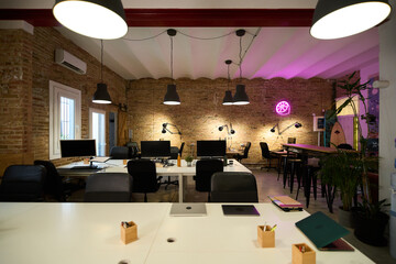 Modern coworking space with exposed brick walls and hanging lamps