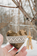Handmade fabric heart made of camouflage of Ukrainian army forces. Ukrainian symbols hanging on a...