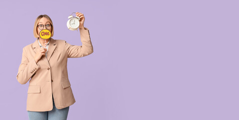 Shocked adult woman with alarm clock holding speech bubble with word OMG on lilac background