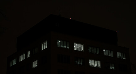 Dark and silent office building at night only a few lights remaining extinguished