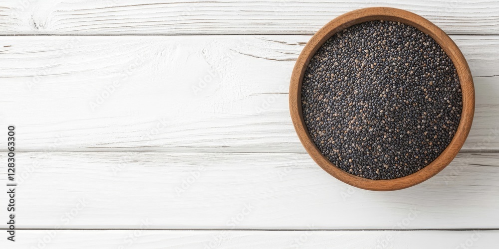 Poster poppy seeds in a natural wooden bowl centered on a white wooden backdrop with negative space for cre