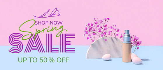 Bottle of makeup foundation, decorative plaster figure and gypsophila flowers on blue table against pink background