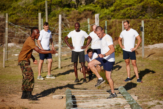 Bootcamp, obstacle course and men with training for fitness, military base and discipline or obedience. Challenge, drill and instruction with sergeant yelling at soldier for development or motivation