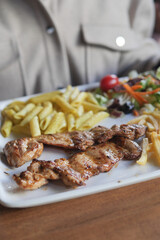 Grilled chicken with fries and salad at a local restaurant