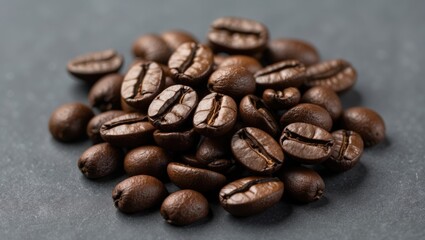 Naklejka premium Close up of dark roasted coffee beans arranged on a textured gray background showcasing their rich color and unique shapes.