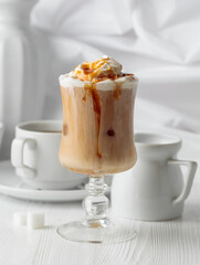 Iced caramel latte topped with whipped cream and caramel sauce.